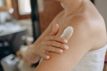 close up female hands and a smear of cream  or lotion or serum  on the skin, woman applies...
