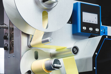 A roll of white paper is passed through the machine. printer and sticker machine, which is used for...