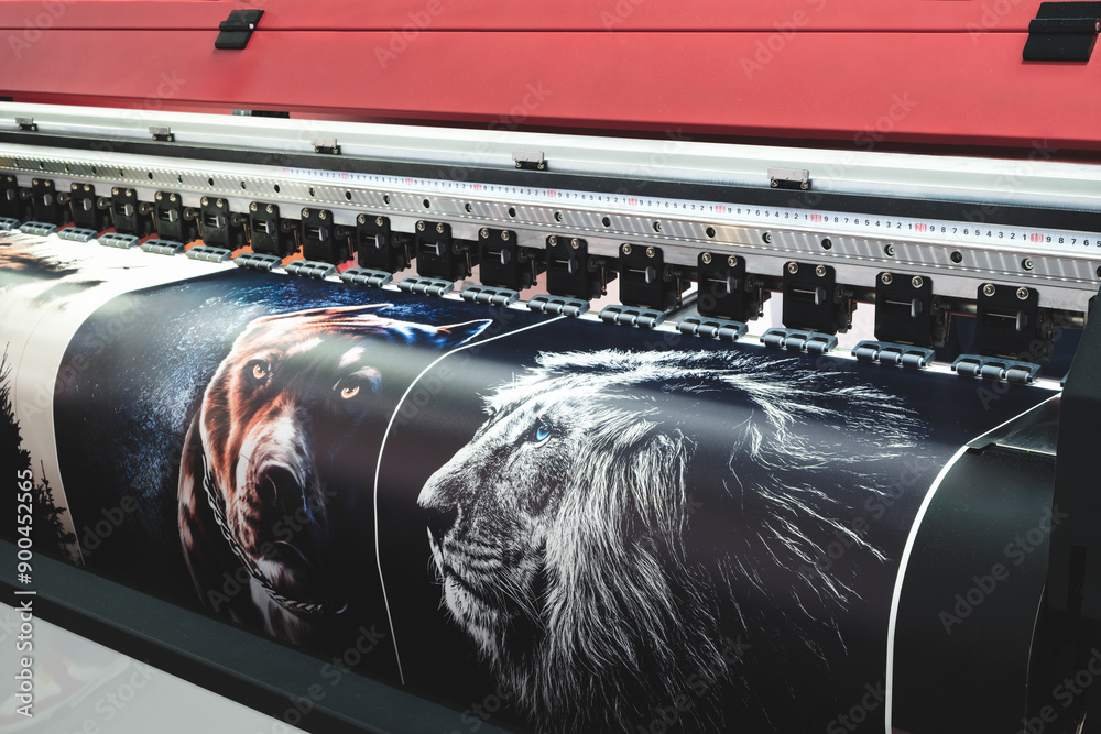Poster a large printer is printing a series of images, including a dog and a lion. the printer is black and