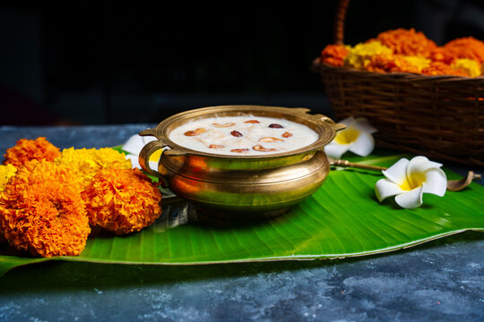 Onam festival image Payasam arranged in brass bowl with flowers on the background 
