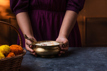 Payasam high quality image, Girl serving payasam in golden uruli, Onam and Vishu festival special sweet dessert