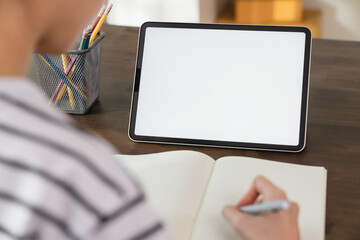 Mock up of woman hand holding digital tablet and touching blank screen.