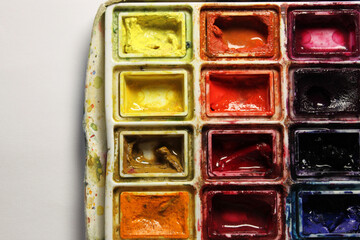 Used watercolor paint palette is showing vivid colors, inspiring creativity for artists and designers