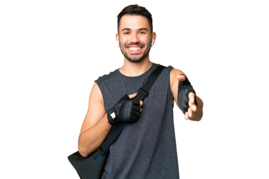 Young sport caucasian man with sport bag over over isolated chroma key background shaking hands for closing a good deal