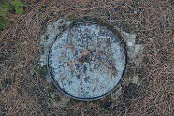 Lonely fire hydrant standing in a vast field surrounded by overgrown grass and weeds