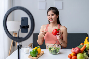 Asian influencer is recording a video blog about healthy food using a ring light