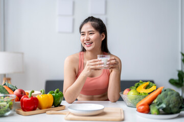 Young woman enjoying a healthy drink surrounded by fresh vegetables