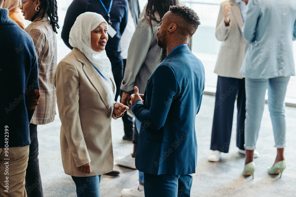 Wall mural networking event with diverse professionals engaging in conversation during a business conference
