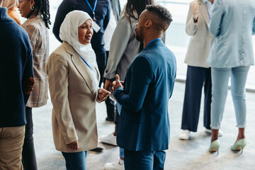 Networking event with diverse professionals engaging in conversation during a business conference