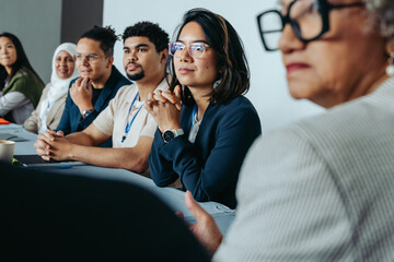 Diverse group of professionals in a boardroom meeting, attentive and engaged