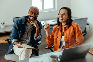 Happy co-workers smiling and collaborating in a modern office setting