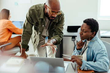 Office discussion between manager and employee during a meeting at work