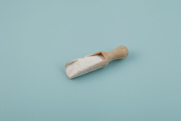 Transglutaminase TG, aka Meat Glue in wooden scoop. Natural enzyme that has the ability to glue protein-containing foods together. White powder microbial TGase or MTGase.