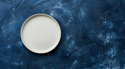 Minimalist white plate sitting on a deep navy blue background with a raw, stylish vibe.