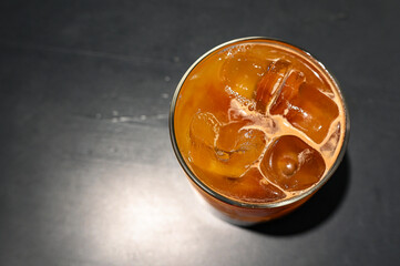 Top view of glass with bumble coffee or bumblebee coffee with orange juice and ice as summer beverage
