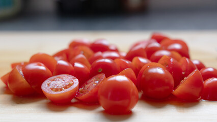Close-up of halved cherry tomatoes on wooden cutting board