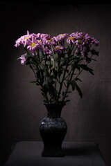 bouquet of lilac chrysanthemums in a vase. taken in close-up on a gray background with space for text. still-life