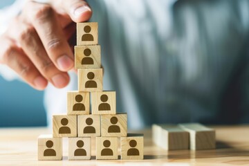 Building a Strong Team: A close-up shot of a hand strategically placing a wooden block with a person icon, symbolizing the construction of a successful and collaborative team. 