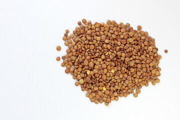 Brown lentils neatly piled on a white surface, showcasing natural textures. Ideal for vegetarian and vegan diets, agriculture projects, white background