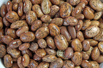 Bountiful pile of nutritious pinto beans forms a richly textured background, showcasing these healthy legumes in all their natural glory