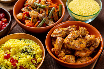 Couscous with dried fruits, chicken in spices and vegetables stewed on the table