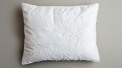 Obraz premium Elegant white pillow with ornate embroidery, set against a seamless background, providing ample space for copy text