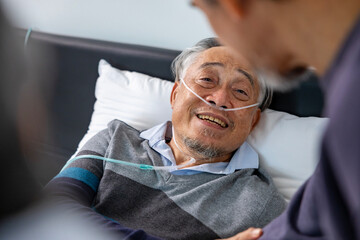 Senior fatal dying male patient with oxygen mask is getting consoling support from his friend and...