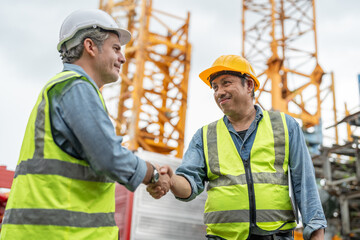 Business owner man handshake with Asian senior supervisor foreman to agreement rent tower crane for...