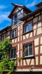 Baby announcement. Siege of stork with pink and blue packages in a beak, located on the facade of a half-timbered medieval house in Meersburg, Germany. Beautiful tradition.