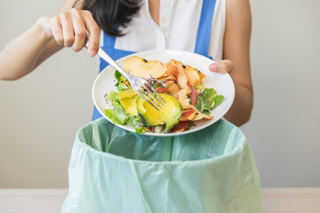Compost from leftover food asian young housekeeper woman, female hand holding salad bowl use fork...