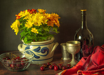Still life photograph with a bouquet of marigold flowers, cherries and alcohol, stylized as antique.