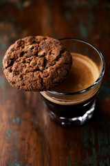 Chocolate cookie and Coffee in glass cup on rustic wooden background. Close up.	