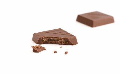 Milk chocolate pieces on a white background