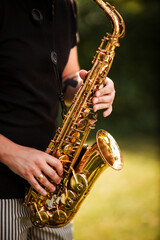 Stylish man in suit, musician, professional saxophonist in suit plays the saxophone. Photography, portrait.
