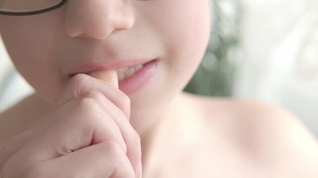 nervous child, 12-year-old boy nervously biting fingernails, nail-biting as coping mechanism to deal with stress, nervous tick habit, teenage nervousness, anxious preteen