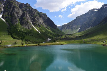 Alpine Lake with reflection of Clouds and mountains - Rainbow Lake Domel, Minimarg, Gilgit Baltistan, Pakistan