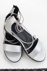 Elegant silver women's sandals without heels. Women's fashionable shoes on a white background