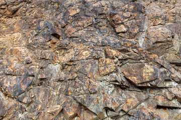 Rock, background, texture, patterns on rock stones. Orange stone texture. Red brown stone background. Rock surface. Mountain texture. Close-up. Natural rock surface, background