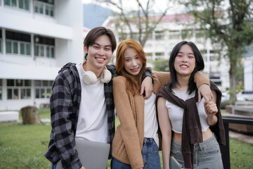 Fototapeta premium Three young people smiling and having fun together on a university campus, enjoying their student life