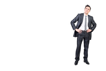 Thoughtful man in formal suit keeping hands on waist