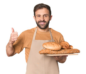 Hispanic male baker with bread tray smiling and raising thumb up