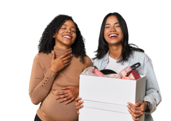Latin women couple moving, one pregnant  laughs out loudly keeping hand on chest.