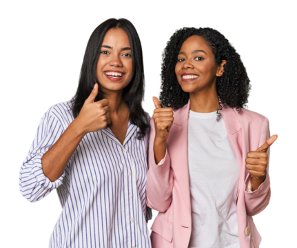 Young Latin businesswomen in studio raising both thumbs up, smiling and confident.