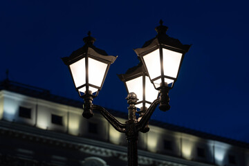 Vintage street lamp on the background of the building, in the evening in the city