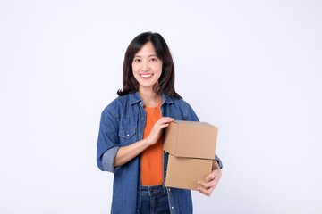 Obraz premium Portrait young asian woman wearing orange t-shirt and denim shirt holding parcel box isolated on white studio background, Delivery courier and shipping service concept.
