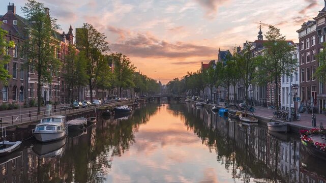 Vibrant sunrise with tipical dutch houses reflected in the city center canals, Amsterdam, Netherlands - Timelapse - 4k