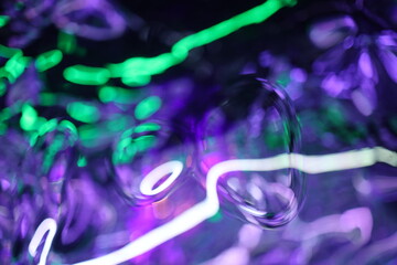 Abstract Glittered Textured Radial Foil Neon Light on Black Background, shapes of liquid chrome...