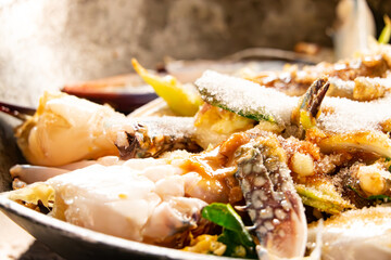 A plate of food with a lot of seafood and a lot of ice. The seafood is mostly octopus and the ice is covering it