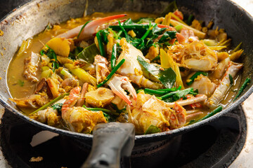 A large pot of food with a lot of meat and vegetables in it. The food is brown and looks very tasty