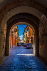 Fototapeta premium A view through the old medieval fortification controlling entry to Castel San Pietro Terme, Italy in summertime